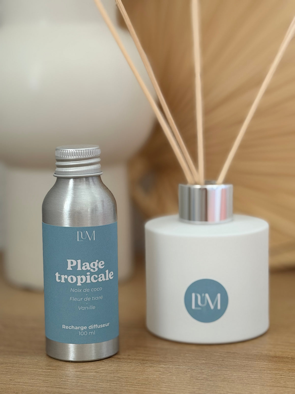 gros plan recharge et diffuseur blanc mat plage tropicale avec bâtonnets rotin.